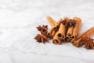 Cinnamon sticks and anise on a textured background. Cinnamon roll and star anise. Spicy spice for...