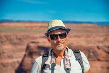 A man visiting the famous Horseshoe Bend Canyon on a summer day