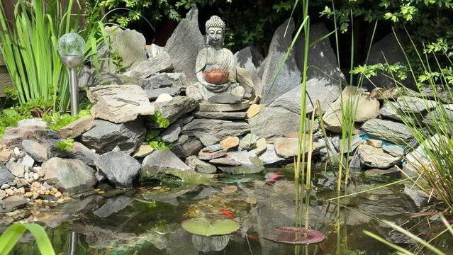 Buddha in a Japanese garden with a pond and koi for peace and relaxation 4k 