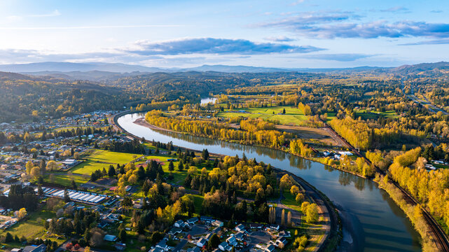 Autumn in Washington State, USA. Drone approaching the narrow river in Castle Rock with beautiful mountains at backdrop.