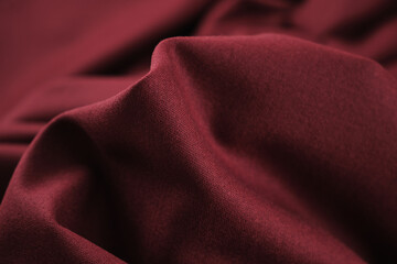 Close-up of burgundy colored suit fabric texture, abstract background.