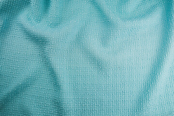 Texture of draped wool light blue fabric, top view, textured background.