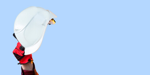 Hardhat in hands of man. White helmet for builder. Industrialist protective headgear. Hardhat on blue background. Clothes for construction workers. Hardhat made of white plastic. Industrial helmet