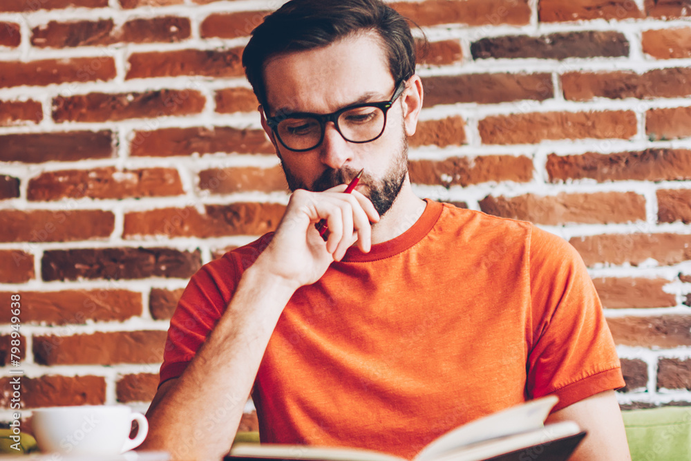 Aufkleber concentrated smart hipster student learning information from textbook preparing for seminar.pensive 
