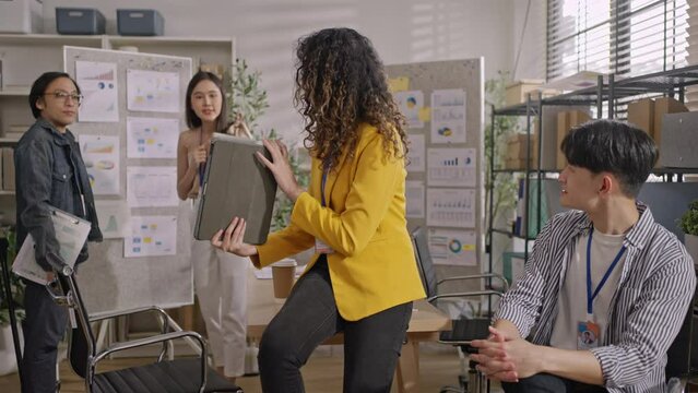 Creative designe Asian team brainstrom standing brainstrom discuss business startup team ideas,branding project with designer team at meeting table with desktop computer.discussion idea in office