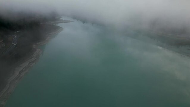 Lago de Barcis, Lago en Italia, entre las mota&ntilde;as de los alpes que pertenece a los dolomitas, drone video en Italia, nubes.