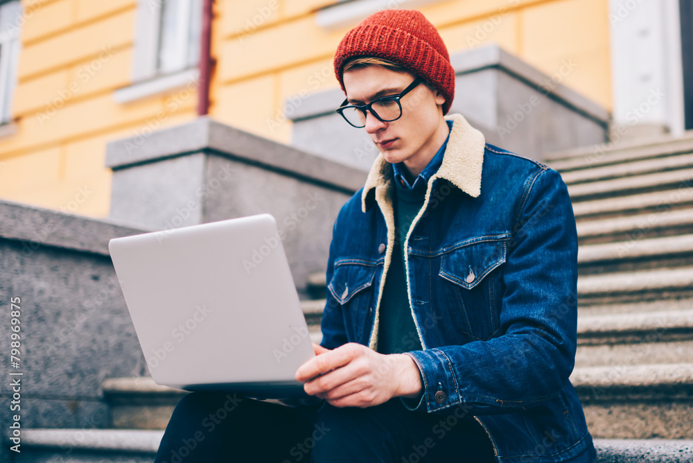 Poster pensive hipster student reading mail and notification on laptop computer connected to free 4g intern