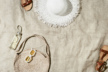 Beach still life at summer sun, fashion jute beach bag, detox lemon water, sun hat, brown sandals...