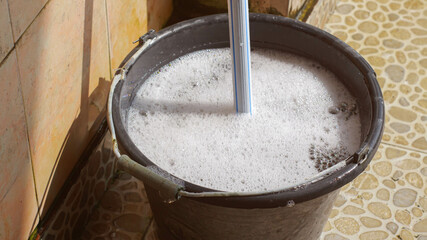 A mop and a bucket of soapy water.