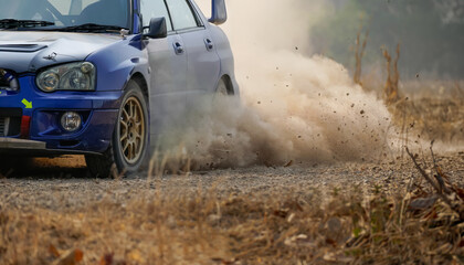 Rally racing car turning in curuve on dirt track.