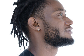 A profile portrait of a young man with dreadlocks