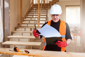 Man builder at work. Worker in building under construction with steps. Construction engineer...