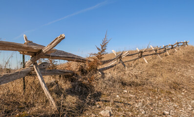 old wooden rail fence on the side of a hill