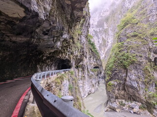 Taroko, Taiwan - 11.26.2022: Partly opened section of Swallow Grotto Trail with no people under marble cliffs along Liwu River in a gorge in the mist before the 403 earthquake during the pandemic