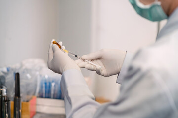 surgery doctor preparing filling syringe medicine for procedure. medical staff preparing therapy operation by adding liquid from vial. cosmetologist ready medicine syringe needle for plastic surgery - Powered by Adobe