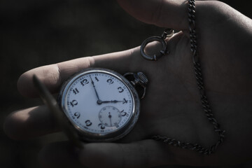 silver pocket watch with chain in hand black and white, passing time, significant moment,...