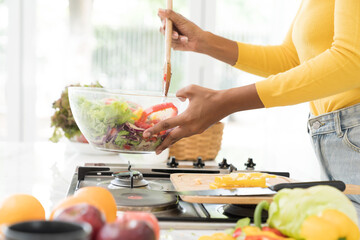 Hands of woman cooking salad in kitchen room at home