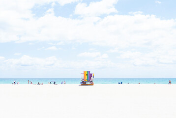 Rainbow Lifeguard Tower on Miami Beach Florida with a Pastel Backdrop of Sand, Sea and Sky, and a Few People Scattered Along the Shore