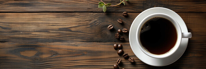Top view of a fresh cup of coffee with roasted beans on a rustic wooden table.
