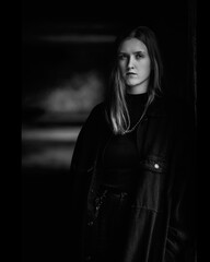 Portrait of a young beautiful girl in dark clothes. Black and white photo.