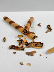 Crispy chocolate wafer roll sticks with crumb isolated on white background