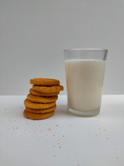 Glass of milk with a pile of coconut biscuits