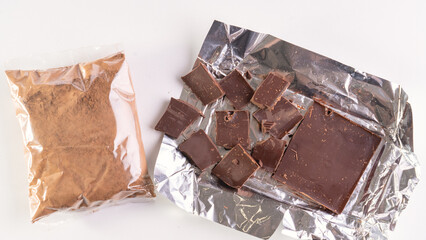 Cocoa and chocolos on white background, concept of price increase for raw materials of chocolate production.