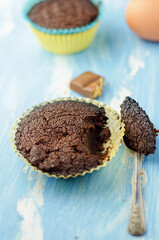 Chocolate cupcake on blue background.
