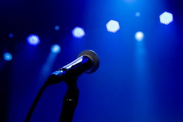Blue concert lights with microphone without singer. empty stage