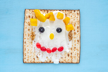 Matzah toast made with white chocolate, mango pieces, blueberries, candies and walnuts on blue...