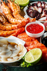 Vibrant assortment of fresh seafood including shrimp, octopus, scallops, and salmon, garnished with...