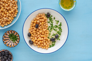 Chickpeas served with black olives, chopped cilantro, olive oil..