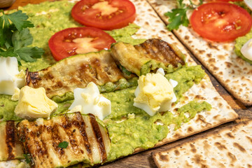 Matzah toast made with creamy avocado, grilled zucchini, fresh tomatoes, boiled eggs..
