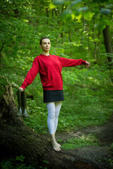 Girl in rubber boots posing in a spring forest, surrounded by blossoming trees and vibrant greenery, exuding the essence of nature's renewal.