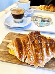 Wooden board with Croissants served with spanish coffee cafe bombon in andalusian cafe in Malaga, Spain.