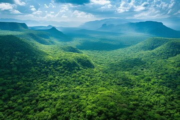 Lush green mountains pierce a vibrant summer sky with wispy clouds in this scenic landscape
