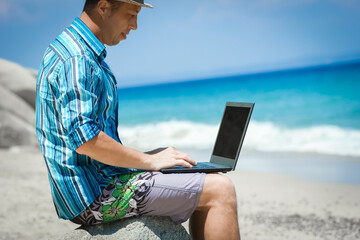 A Happy man guy with laptop near the seashore weekend travel - 799132612