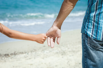 A Hands of a happy parent and child on the seashore on a journey trip in nature - 799133095