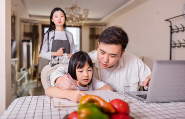 A family of three in the living room painting with their daughter
