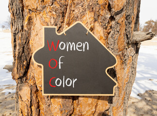 WOC women of color symbol. Concept words WOC women of color on beautiful yellow blackboard. Beautiful tree wooden background. Business WOC women of color social issues concept. Copy space. - obrazy, fototapety, plakaty