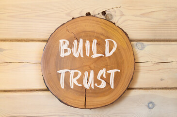 Build trust symbol. Concept words Build trust on beautiful wooden circle. Beautiful wooden wall...
