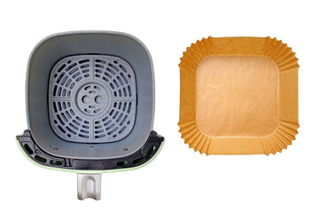 Top view of empty air fryer's basket and disposable greaseproof wax paper liner isolated on white background with clipping path. Healthy cooking concept without contaminating the fryer.