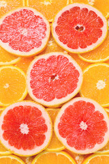 Slices of oranges and a grapefruits as a background.