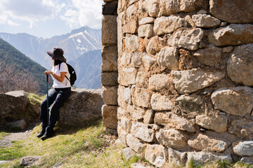 Hiker woman making pilgrimage path next to a Romanesque church in the Spanish Pyrenees with...