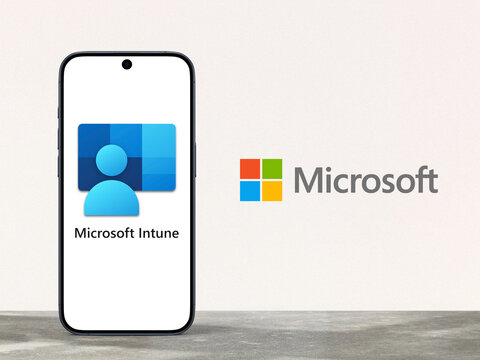 Microsoft Intune logo displayed on a modern smartphone standing on a desk, Microsoft logo next to it, cloud-based unified endpoint management service, Microsoft Azure