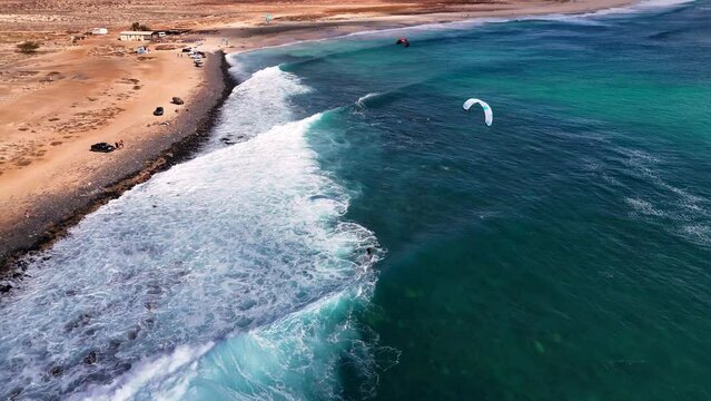Following a kitesurfer in Ponta Preta, Sal, Cape Verde, surfing a breaking wave