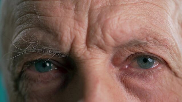 Portrait of elderly man with blue eyes. Close-up of old people eyes