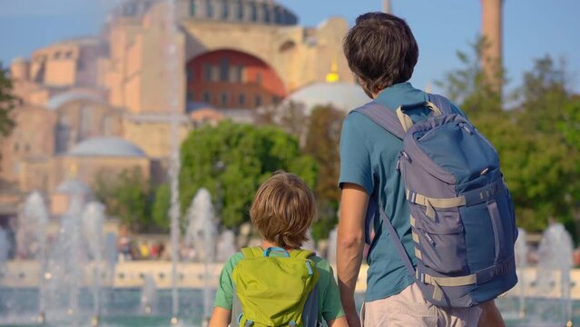 Father and son backpackers admire the grandeur of Aya Sophia, soaking in the ancient beauty of Istanbul's skyline, their joyful bond over the shared love of travel emanating amidst the historical