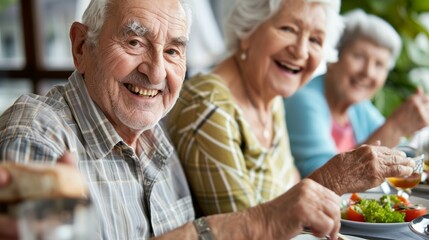 Happy senior friends having fun cheering with red wine at barbecue in terrace outdoor - Mature people making dinner toasting glasses and laughing together - Friendship and elderly lifestyle concept