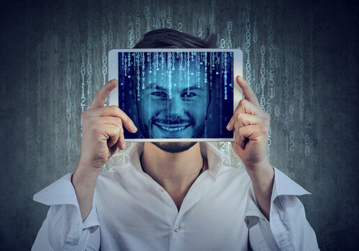 Happy man holding tablet with his face displayed on a screen with binary code 